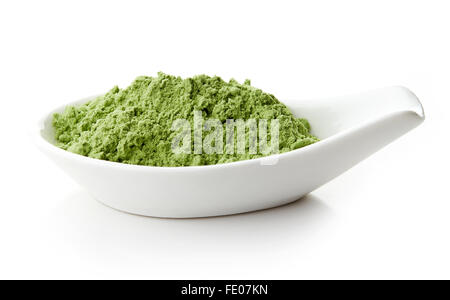 Young barley or wheat grass in white porcelain spoon on white background Stock Photo