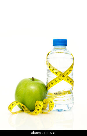 Water bottle wrapped in yellow tape measure with green apple isolated on white background with copy space Stock Photo