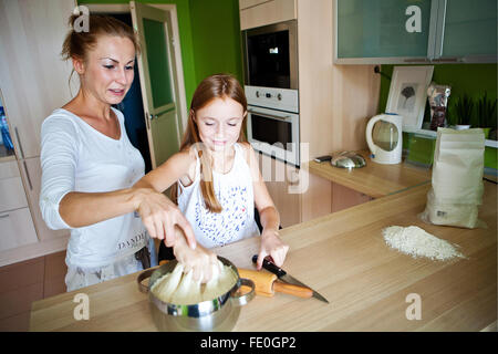 family preparing the dough, mother and daughter Stock Photo