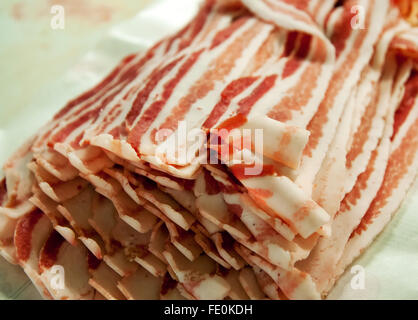 Close up of many slices of bacon in bundle on table in meat processing plant Stock Photo