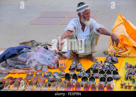 Local man selling slippers at the market by Man Sagar Lake in Jaipur, Rajasthan, India. Stock Photo