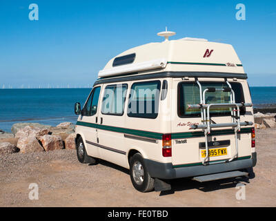 Ford Flair Auto-sleeper camper van parked up on the seaside looking at wind farm Stock Photo