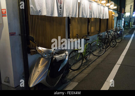 scooters and bicycles outside a capsule hotel Stock Photo