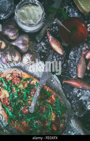 A homemade rustic pizza on a farmhouse kitchen table Stock Photo