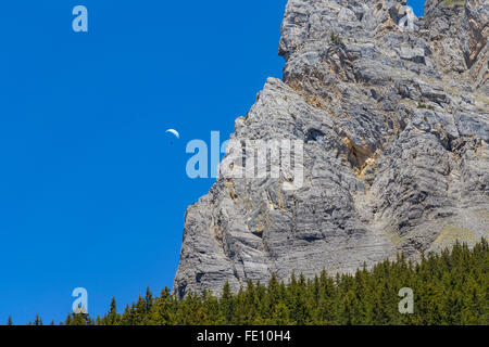 Paraglider against Swiss Alps and clear blue sky near Oeschinensee (Oeschinen lake), on Bernese Oberland, Switzerland Stock Photo