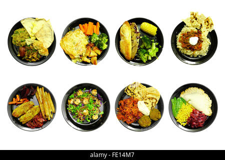 Different meals on black plates photographed against a white background. Stock Photo