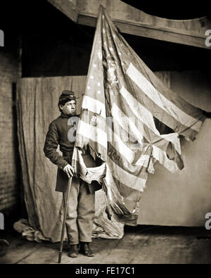 Battle tattered flag of the Pennsylvania Infantry held by a young Union Civil War soldier. Stock Photo