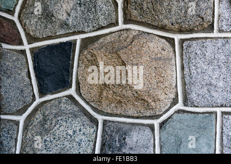 Closeup of multicolored natural veneer stone wall with white mortar Stock Photo