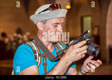 Young man tourist with travel backpack takes a photo shot picture Stock Photo