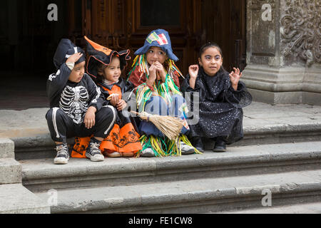 Children in Halloween costumes sitting on church steps, Oaxaca City, Oaxaca, Mexico Stock Photo