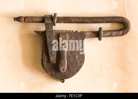 Big, old padlock on adobe wall, Oaxaca, Mexico. Strong security concept. Stock Photo