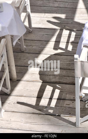 chairs and tables shadows on wooden floor Stock Photo