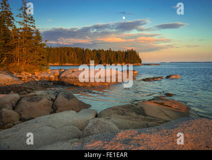 Deer Isle, Maine: Evening light and moonrise on the rocky shoreline of Deer Isle Stock Photo