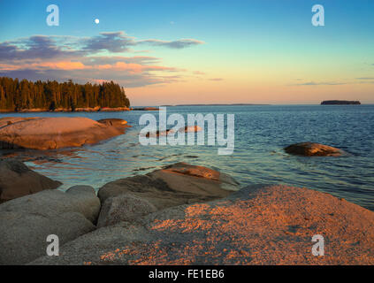 Deer Isle, Maine: Evening light and moonrise on the rocky shoreline of Deer Isle Stock Photo