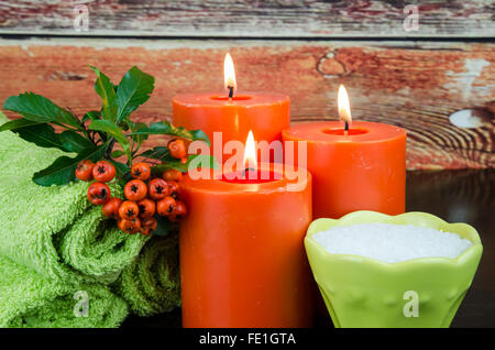 burning orange candles, mineral salt,orange berry and towel still life Stock Photo