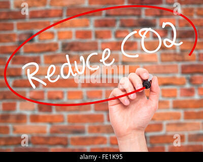 Man Hand writing Reduce CO2 with black marker on visual screen. Isolated on background. Business, technology, internet concept.  Stock Photo