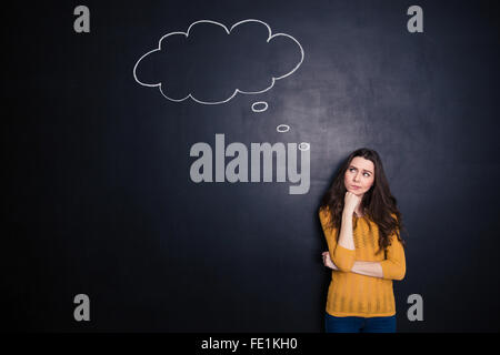 Portrait of a pensive woman standing over black background Stock Photo