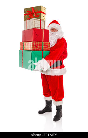 Father Christmas or Santa Claus holding a stack of gift wrapped presents with ribbons and bows, isolated on a white background. Stock Photo