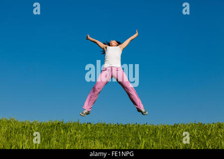 'Real'Woman jumping against blue sky Stock Photo