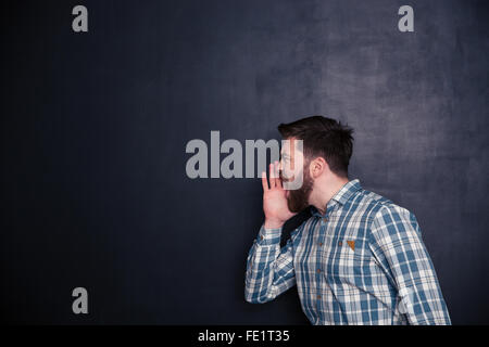 Young man screaming over black background Stock Photo