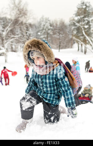 UFA - RUSSIA 16TH JANUARY 2016 - Children enjoy the fresh snow by using improvised slides and sleds to slide down snow banks in Stock Photo