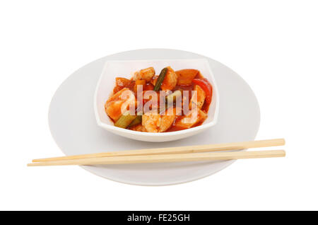 Chinese meal, Chicken Kung Po, in a bowl on a plate with chopsticks, isolated against white Stock Photo