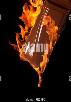 burning melting piece of chocolate in black back Stock Photo