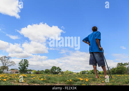 Man with Traumatic Brain Injury standing in a field of flowers Stock Photo