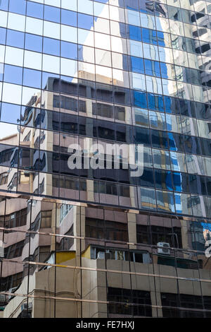 Skyscraper's glass wall and reflection of another buildings on it. Stock Photo