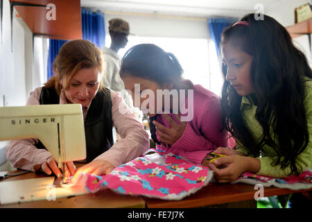 Girls and teacher using sewing machine, tailoring, vocational training, Creciendo Unidos social project, Javier Villa, Bogotá Stock Photo