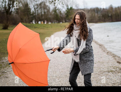 Young woman with umbrella in stormy weather on February 02, 2016 in Munich, Germany.  © Peter Schatz / Alamy Stock Photo Stock Photo