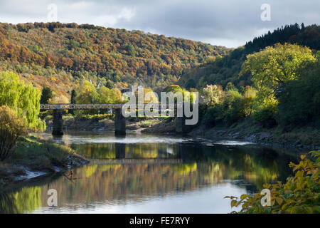 The old Wireworks rail bridge crossing the River Wye at Tintern with the ruins of Tintern Abbey in the background, Monmouthshire, Wales Stock Photo