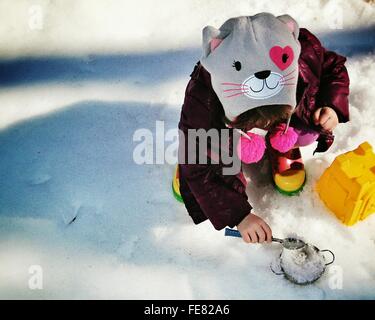 High Angle View Of Little Girl Playing In Snow