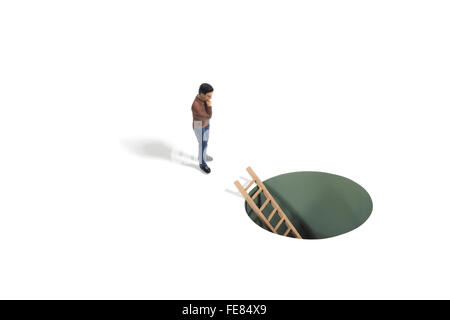 Studio Shot of a Toy Ladder in Hole and a Human Figure Stock Photo