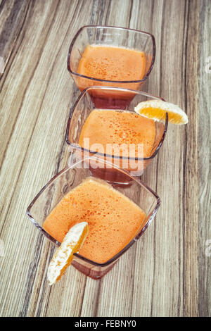Three portions of refreshing smoothie on the wooden background. Healthy lifestyle. Drinks theme. Stock Photo