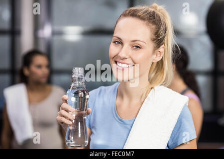 Female trainer holding water of bottle and towel Stock Photo