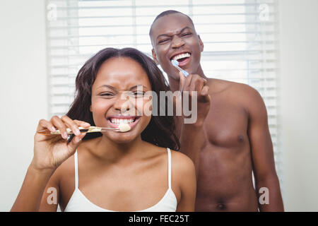 Ethnic couple brushing their teeth Stock Photo