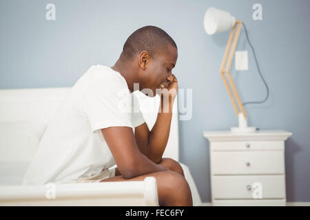 Handsome man sitting on his bed Stock Photo