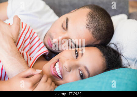 Young couple hugging lying on the couch Stock Photo