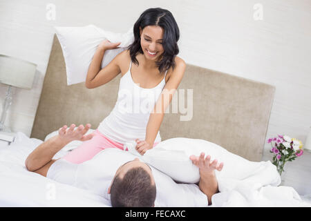 Happy couple having a pillow fight Stock Photo