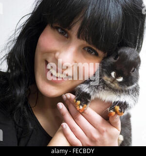 A young woman holding a pet rabbit, close-up Stock Photo