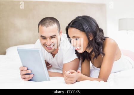 Young couple using laptop in bed Stock Photo