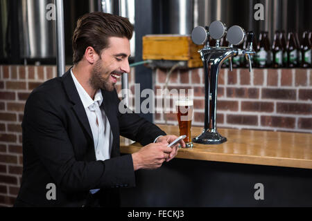 Handsome businessman texting on his phone Stock Photo