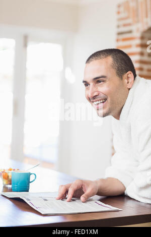 Smiling man drinking coffee while reading a magazine Stock Photo