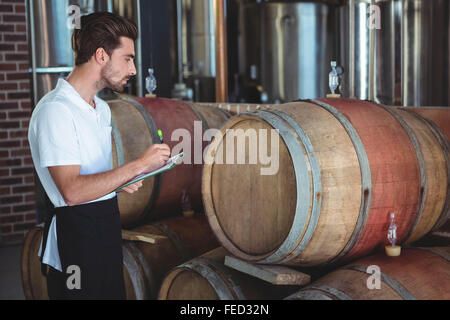 Winemaker taking notes on clipboard Stock Photo