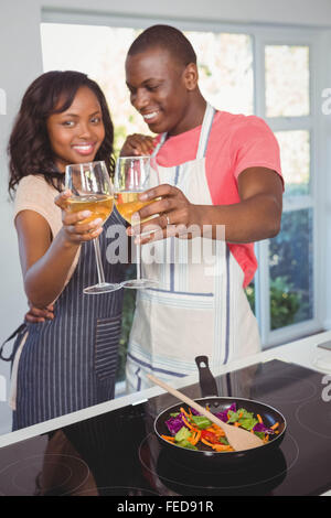 Ethnic couple drinking wine and cooking Stock Photo