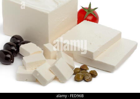 Fresh Feta cheese with slices and cubes, capers,tomato and black olives on white background