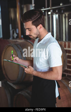Winemaker taking notes on clipboard Stock Photo