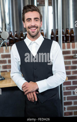 Handsome barman leaning on counter Stock Photo