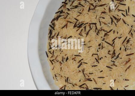 Uncooked long grain and wild rice in bowl Stock Photo